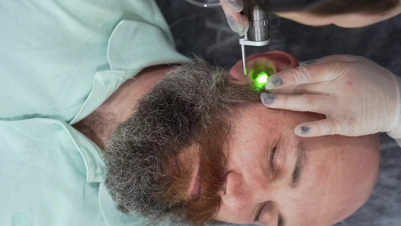 Older man having his ear examined with an otoscope