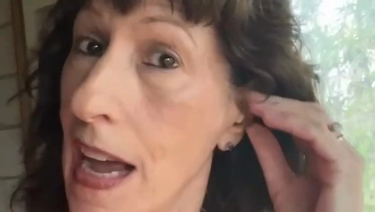 Woman wearing the hearing aid, barely visible in her ear